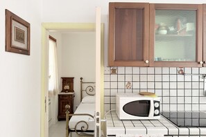 A room with a bed, a wooden cabinet, a microwave, and a tiled backsplash. - N290 - Numana, three-room apartment with terrace overlooking the sea (Numana)