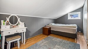 Makuuhuoneessa on sänky, peilillä varustettu meikkipöytä, penkki, pieni pöytä ja matto.