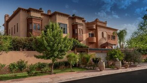 A large, multi-story building with a beige facade, multiple windows, and a prominent entrance. - Hôtel Riad Airport Marrakech (Marrakech)