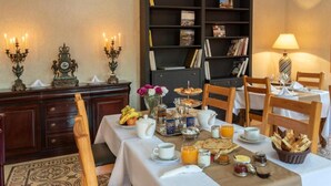 A breakfast setting with a table set for two, including bread, pastries, fruit, and beverages. - Hôtel Riad Airport Marrakech (Marrakech)