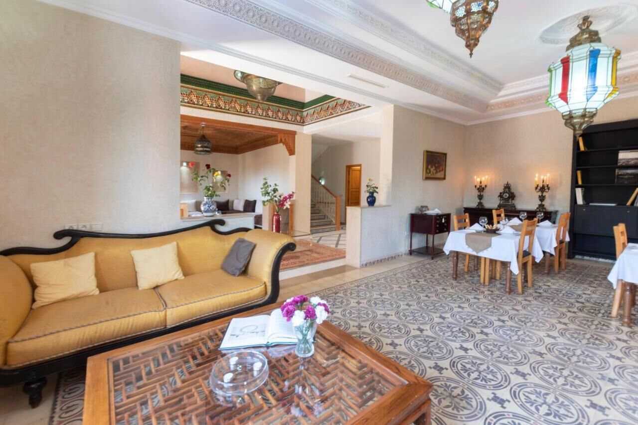 A spacious lobby with a sofa, dining area, and staircase.