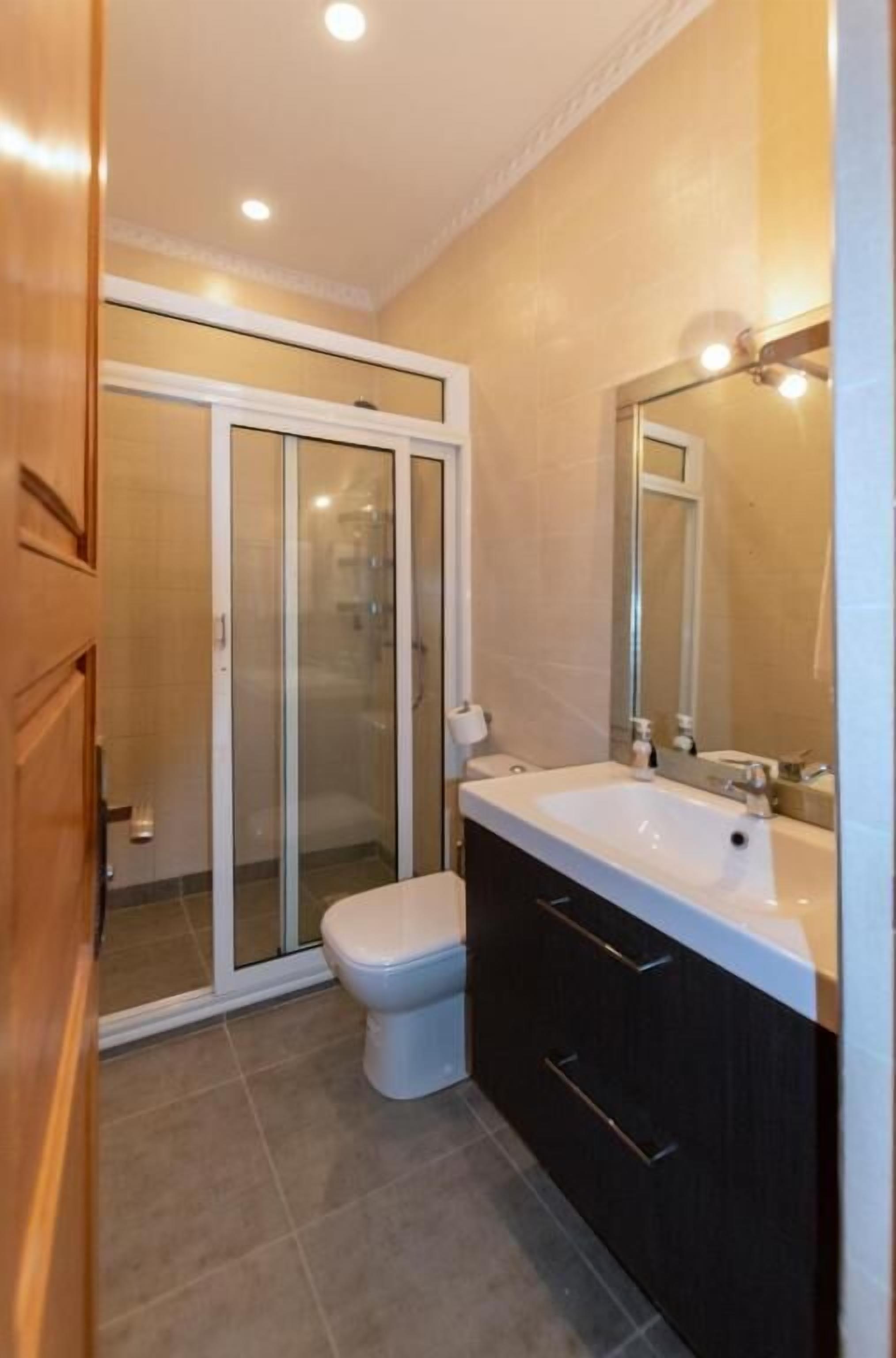 Une salle de bain avec des toilettes, un lavabo et un miroir.