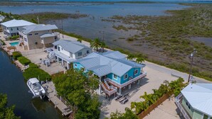A coastal property with multiple houses, a dock, and a beach. - Lux Canal Front 4 bedroom - Home w/ Dock, Near Looe Key – Fishing, Diving & Sunsets! (Ramrod Key)