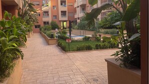 Une cour dallée, entourée d’immeubles résidentiels à plusieurs étages dotés de balcons.