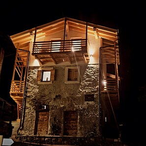 Un edificio de piedra con un balcón de madera y una ventana pequeña.