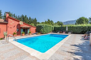 Une piscine rectangulaire à l’eau d’un bleu limpide, entourée d’une terrasse carrelée.