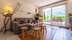 A cozy living area with a sofa, wooden stools, a table, and a lamp.