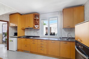 A kitchen with wooden cabinets, a built-in stove, a sink, and a window with a view.