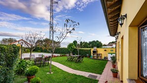 A well-maintained garden with a patio, outdoor seating, and a pathway leading to a building. - Country House 'Apartamento Rosa' with Shared Garden (Susacasa)