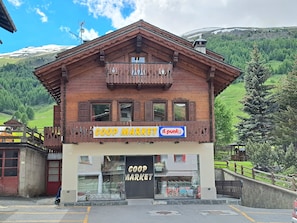 Un edificio de madera con un letrero para un mercado Coop e Il Punt.