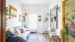 Ein gemütliches Wohnzimmer mit einer Couch, einem Sessel und einem großen Spiegel.