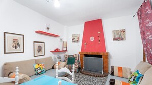 Ein Wohnzimmer mit Kamin, Sofas, einem Couchtisch und verschiedenen Wanddekorationen.
