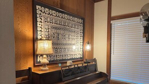 A room with a wooden piano, a wall with intricate patterns, a lamp, and a window with blinds. - Walk to Village!  Clean 2BDRM Palisades Tahoe Condo: Hikes, Dining, Wifi (Olympic Valley)