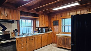 Una cocina con armarios de madera, estufa de acero inoxidable, microondas y refrigerador.