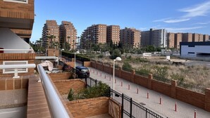A modern urban area with high-rise residential buildings, a paved walkway, and a car parked near the buildings.