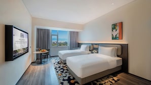 A hotel room with two beds, a dining table with chairs, a TV mounted on the wall, and a large window with a view. - Seaview Gleetour Hotel Shenzhen (Shenzhen)