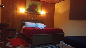 A wooden-paneled room with a bed, a nightstand, and a painting on the wall. - Casa da Dine (Campos do Jordão)