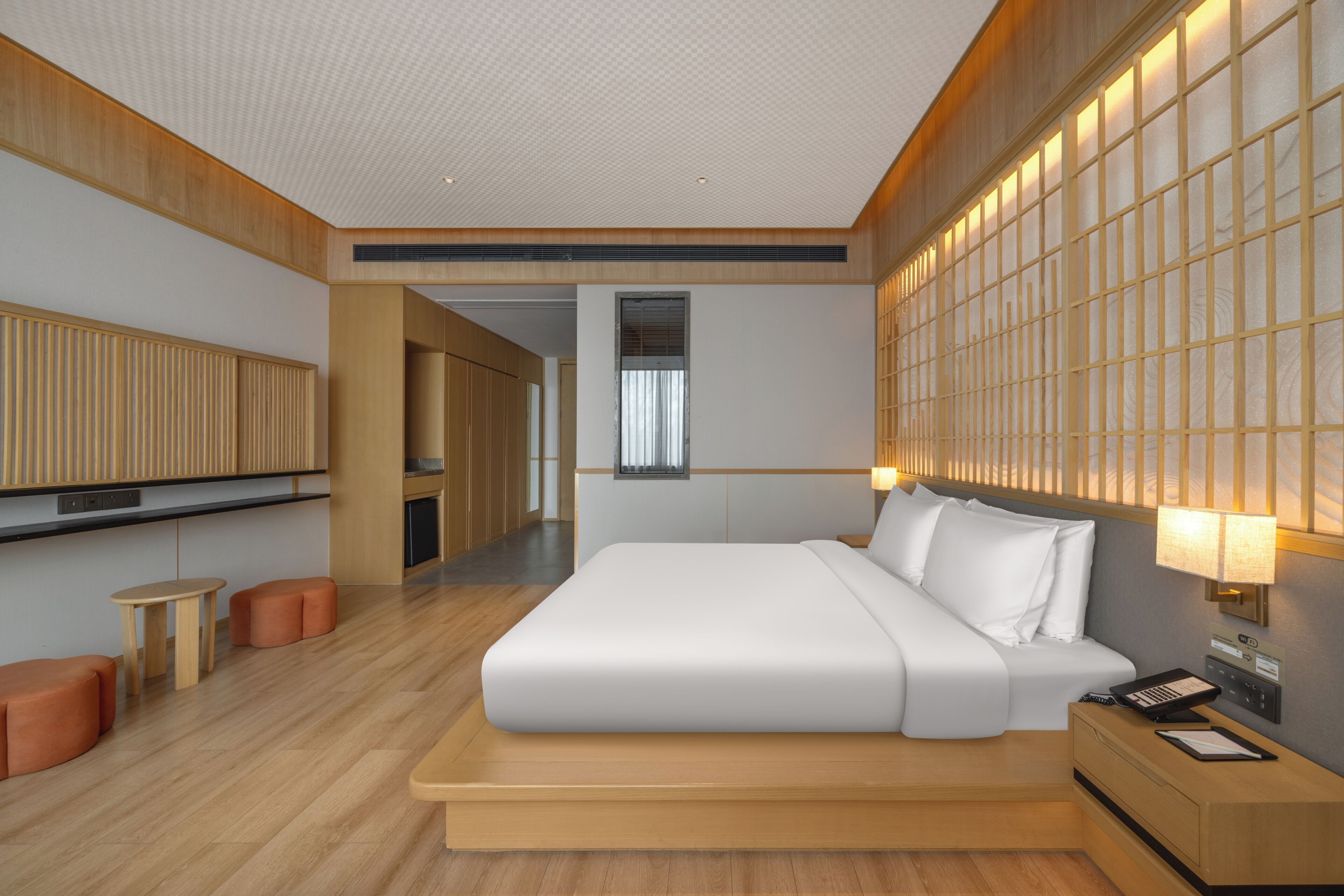 Une chambre d’hôtel moderne avec un grand lit, un bureau, une chaise et une petite table.