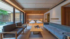 A modern hotel room with a large bed, two sofas, a coffee table, and a view of the outdoors. - Hyakumangoku Onsen Hotel - Free Shuttle Service to Shanghai Disneyland (Shanghai)