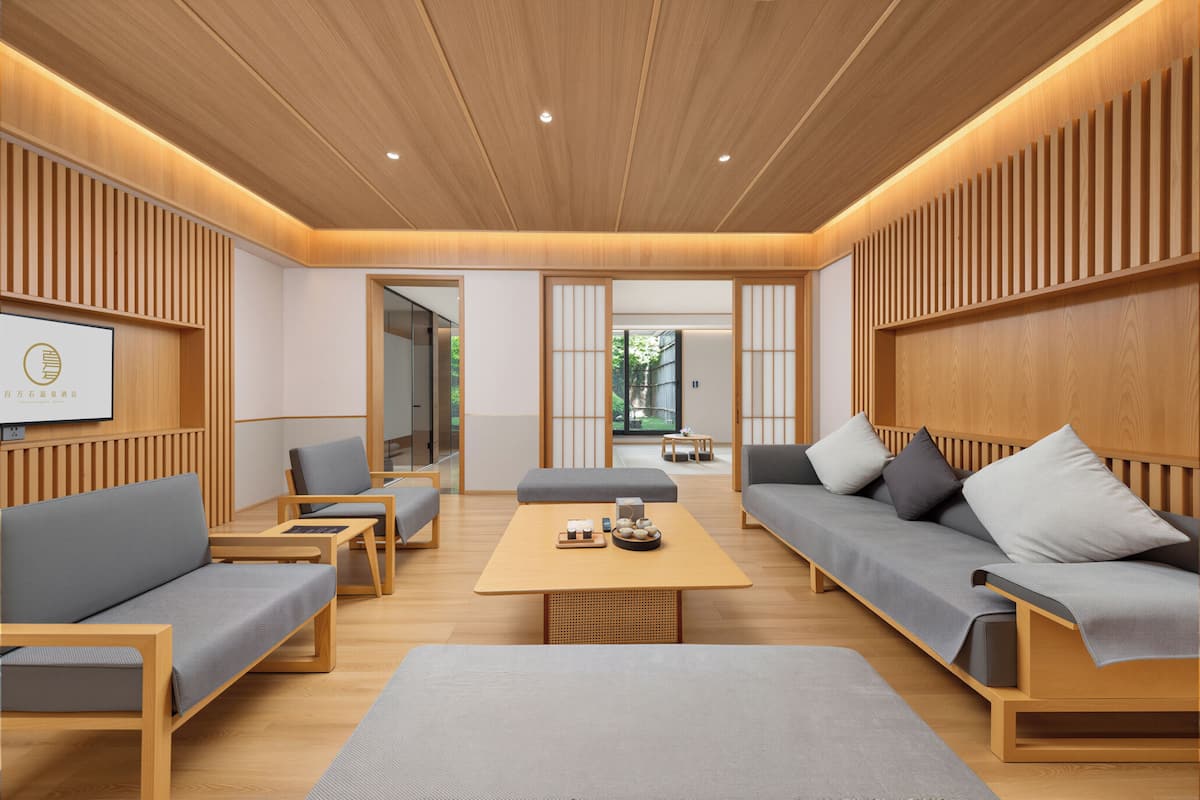 Un intérieur moderne avec des lambris en bois, un canapé, une table basse et un téléviseur.