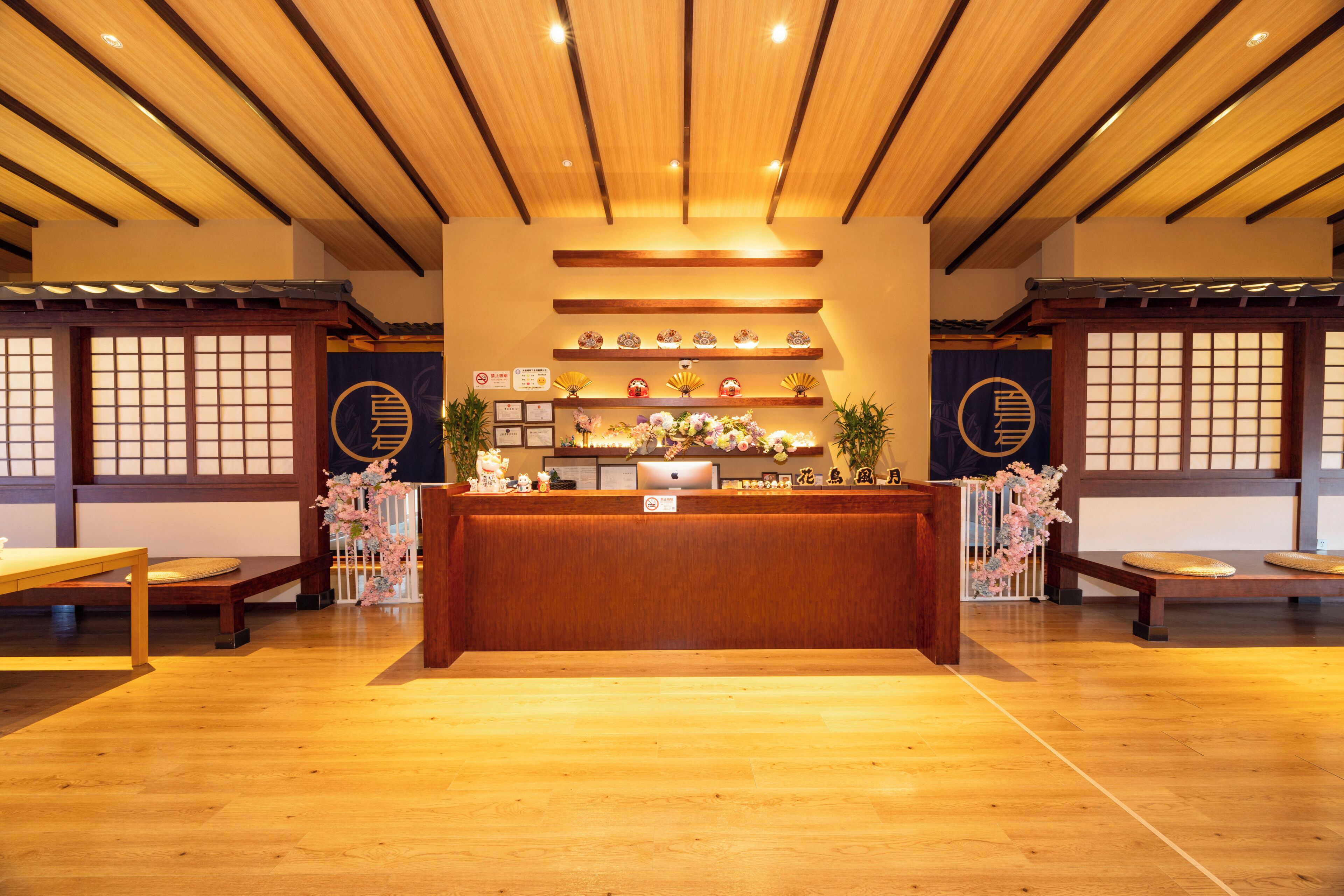 A reception area with a wooden reception desk, wooden flooring, and traditional Japanese decor.