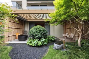 A modern outdoor space with a bamboo fence, a large black planter, and a small water feature. - Hyakumangoku Onsen Hotel - Free Shuttle Service to Shanghai Disneyland (Shanghai)