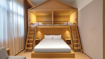 A modern hotel room with a bunk bed, wooden ladder, bedside tables, and a large bed.