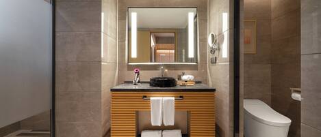 Une salle de bain moderne avec un meuble-lavabo en bois, un lavabo noir, un miroir et des toilettes.
