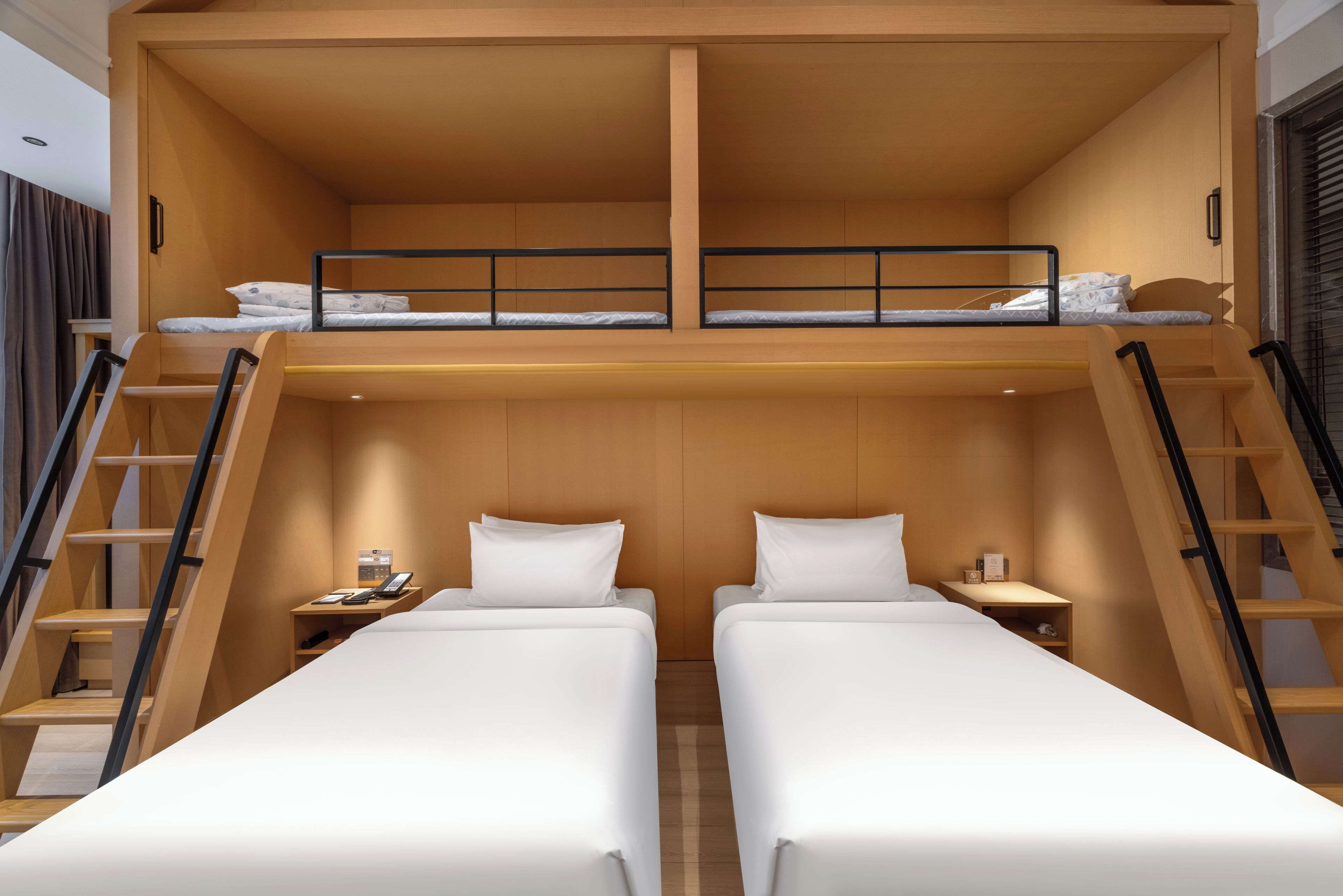 A bunk bed room with two beds, a desk, and a ladder.