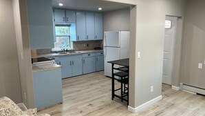 A modern kitchen with light blue cabinets, a black dining table, and a built-in oven.