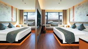 A hotel room with two beds, a large window with a city view, and a painting on the wall. - Chang baishan Hotel (Changchun)