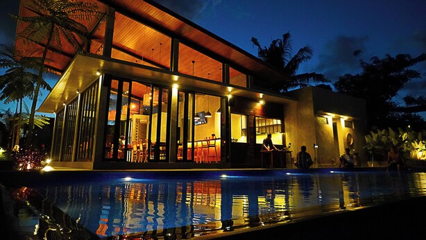 Un edificio moderno con amplios ventanales y piscina.