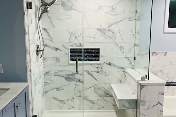 Stand-up shower with seat and dual rainfall shower head.