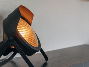 A modern chair with a unique design, featuring a wooden backrest and a black base. - Giethoorn Lakehouse Retreat (Giethoorn)