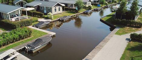 A riverside residential area with houses, docks, and a calm water body.