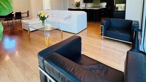 A modern living room with a sofa, a coffee table, and a dining area. - Private luxury — Minutes from City Center & airport (Austin)