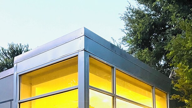 A modern house with large windows, a stone foundation, and a visible interior with furniture. - Private luxury — Minutes from City Center & airport (Austin)