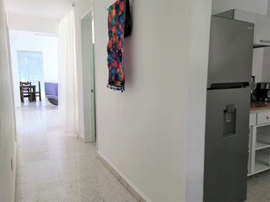 A hallway with a kitchen area on the right, featuring a refrigerator and a coffee maker. - Furnished upstairs apartment ideally located in Oaxaca's Historical District (Oaxaca de Juárez)