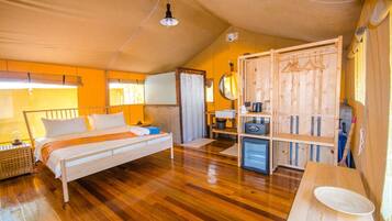 Une chambre confortable avec un lit en bois, un petit bureau, une armoire et un miroir.