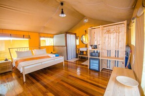 Une chambre confortable avec un lit en bois, un petit bureau, une armoire et un miroir.