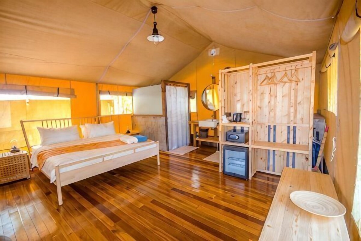 Un dormitorio con una cama de madera, un escritorio, una silla y un armario.