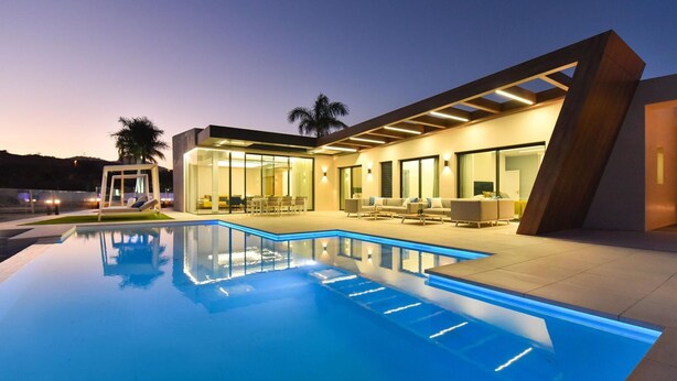 A modern house with a swimming pool, outdoor seating, and a large glass door leading to the interior. - Villa in Salobre With Pool & Golf Nearby (San Bartolomé de Tirajana)