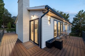 Una casa moderna con terraza, ventanas amplias y chimenea.