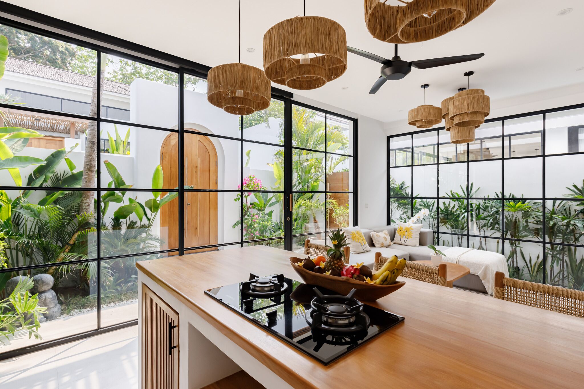 Una cocina moderna con un amplio ventanal, una encimera de madera y un bol de fruta.