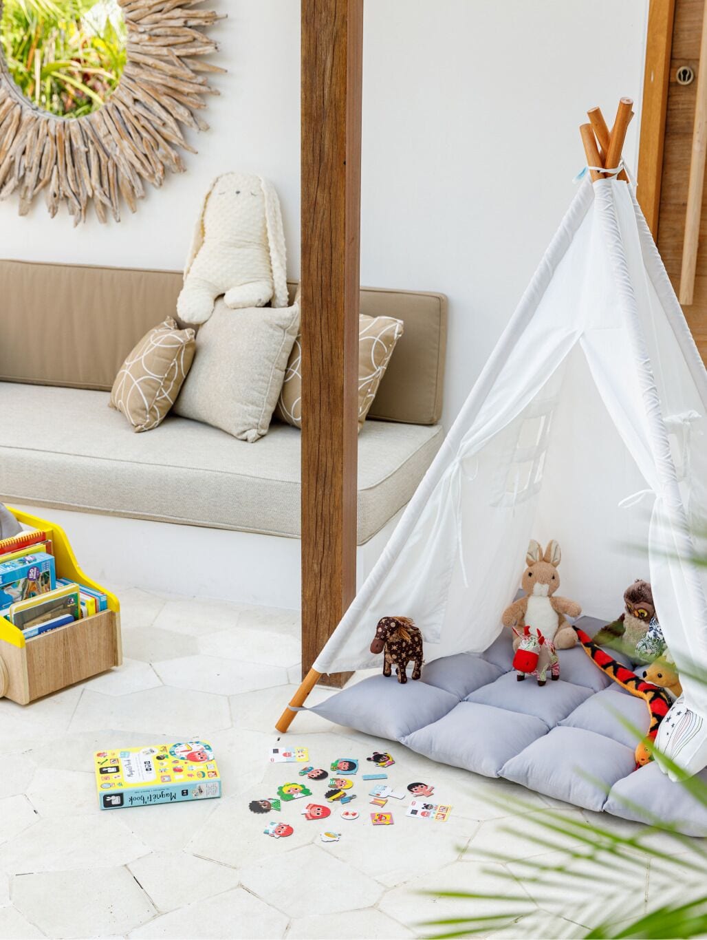 Ein gemütliches Zimmer mit einer Couch, einem kleinen Zelt und einer Spielecke.