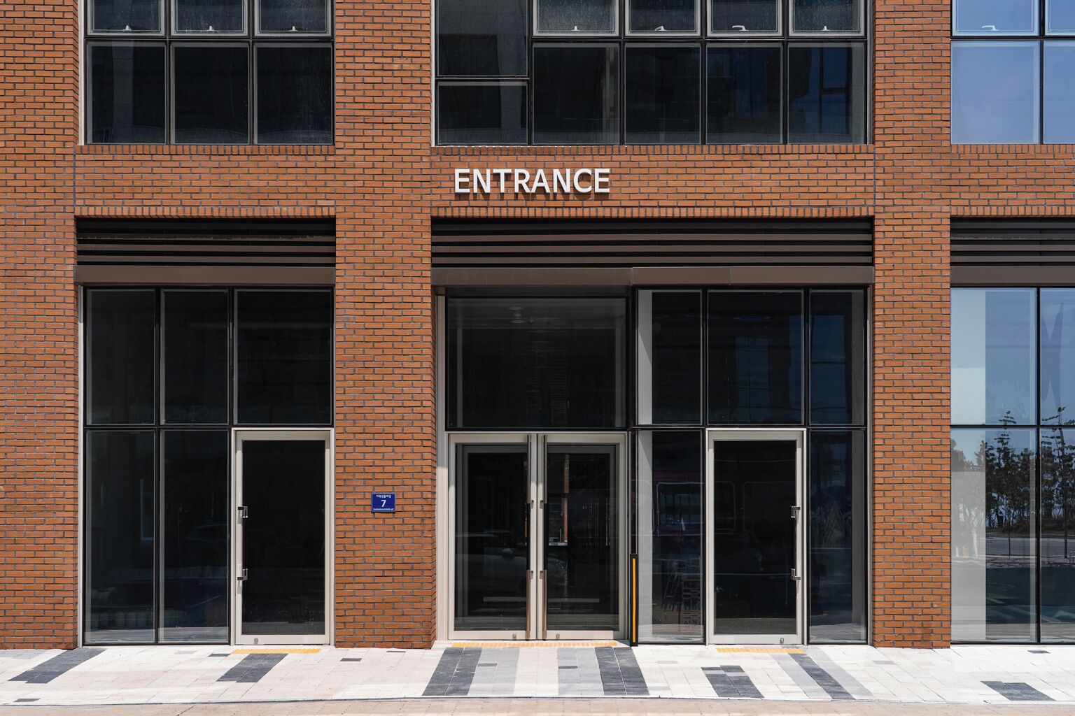A building entrance with a sign reading "ENTRANCE" above the doors.