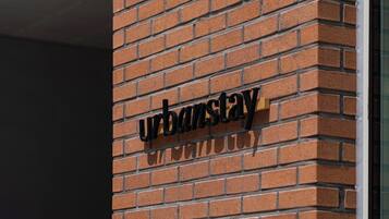 A brick wall with the "UrbanStay" sign.