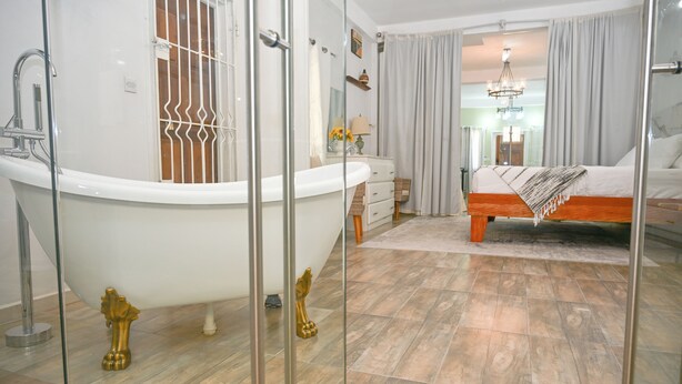 A modern bathroom with a freestanding bathtub, a vanity with a mirror, and a shower area. - Secret Place  (Gros islet)