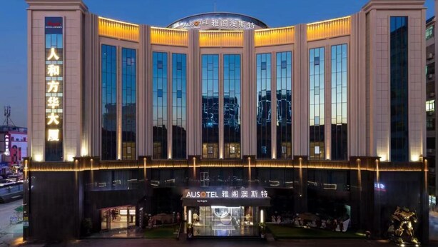 Un hôtel moderne doté d’une entrée imposante, de grandes fenêtres et d’une enseigne lumineuse.