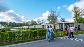 A modern building complex with a paved road and greenery. - Nice Chalet on a Holiday Park 25 km From Amsterdam (Velsen-Zuid)